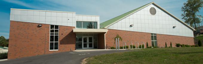 A brick building with an ascending parallel line of white tile.