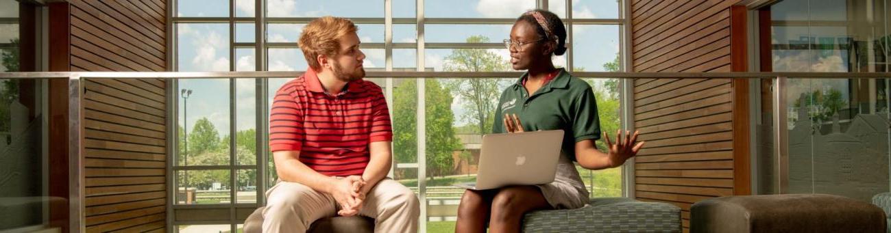 Orientation leader and student talking.