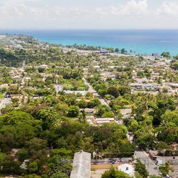 Overview of tree filled city with the coastline in the upper left corner. 